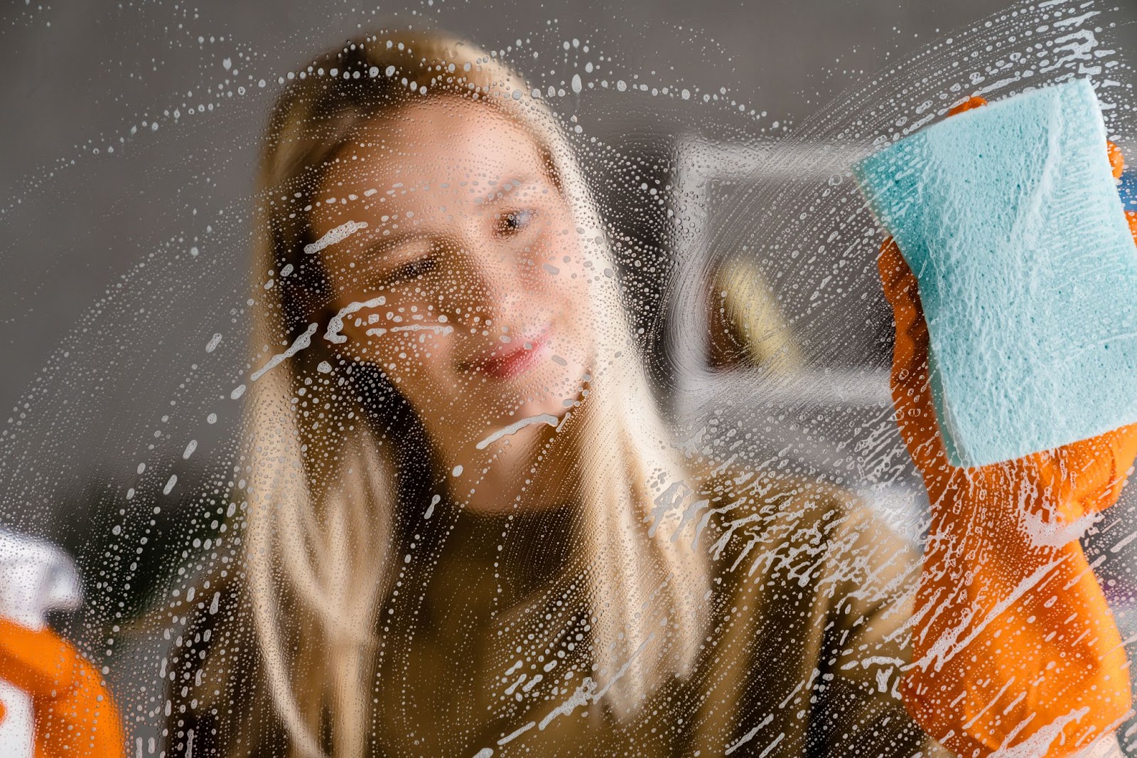 Woman deep cleaning a window with a sponge