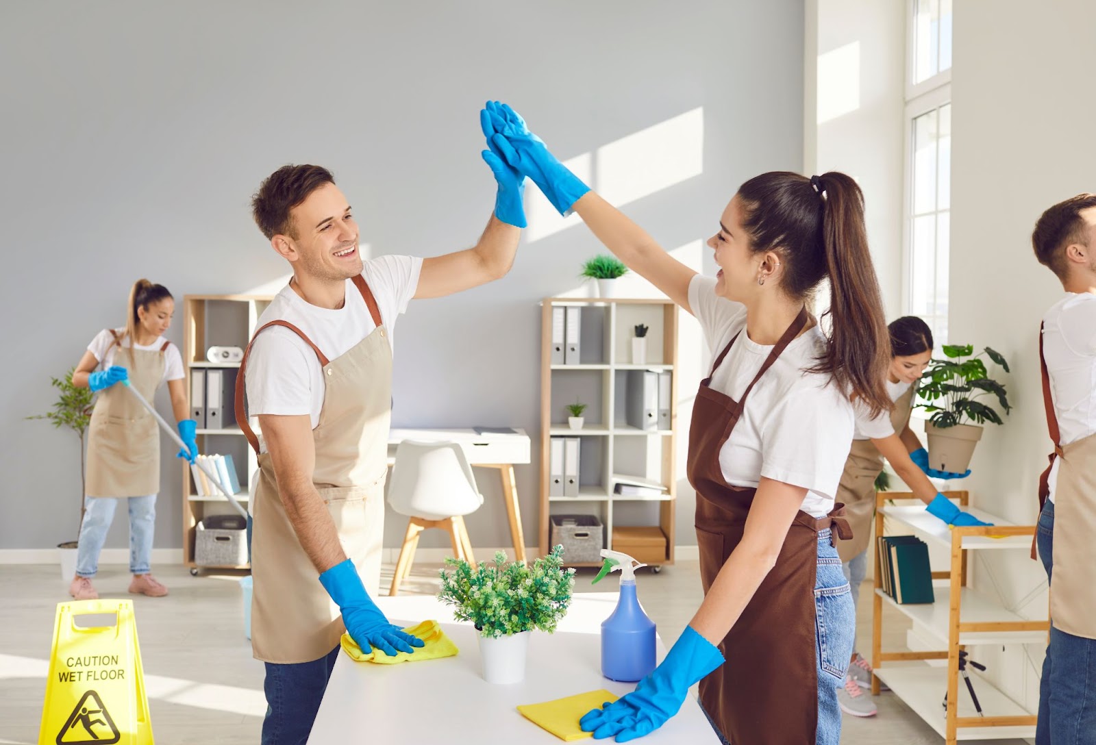 A team of professionals diligently cleaning a room, showcasing the gift of cleanliness and the joy of gifting cleaning services