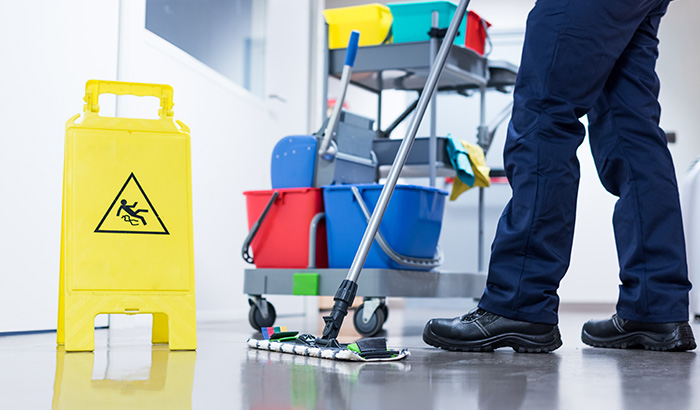A man cleaning the floor with a mop.