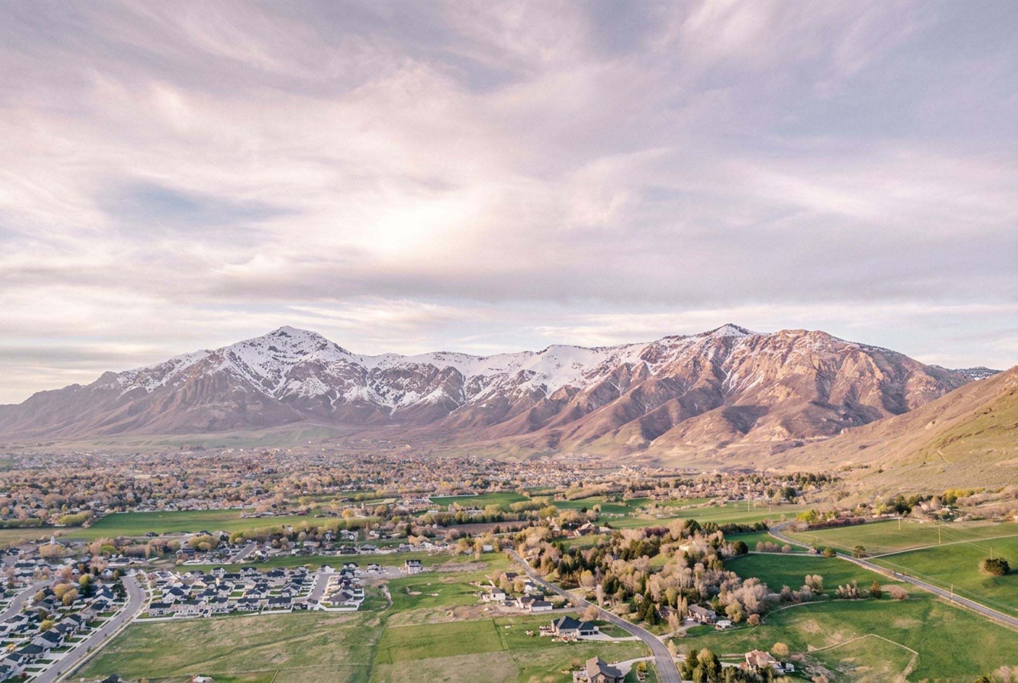Aerial view of a football stadium surrounded by mountains, showcasing the natural landscape and sports venue.