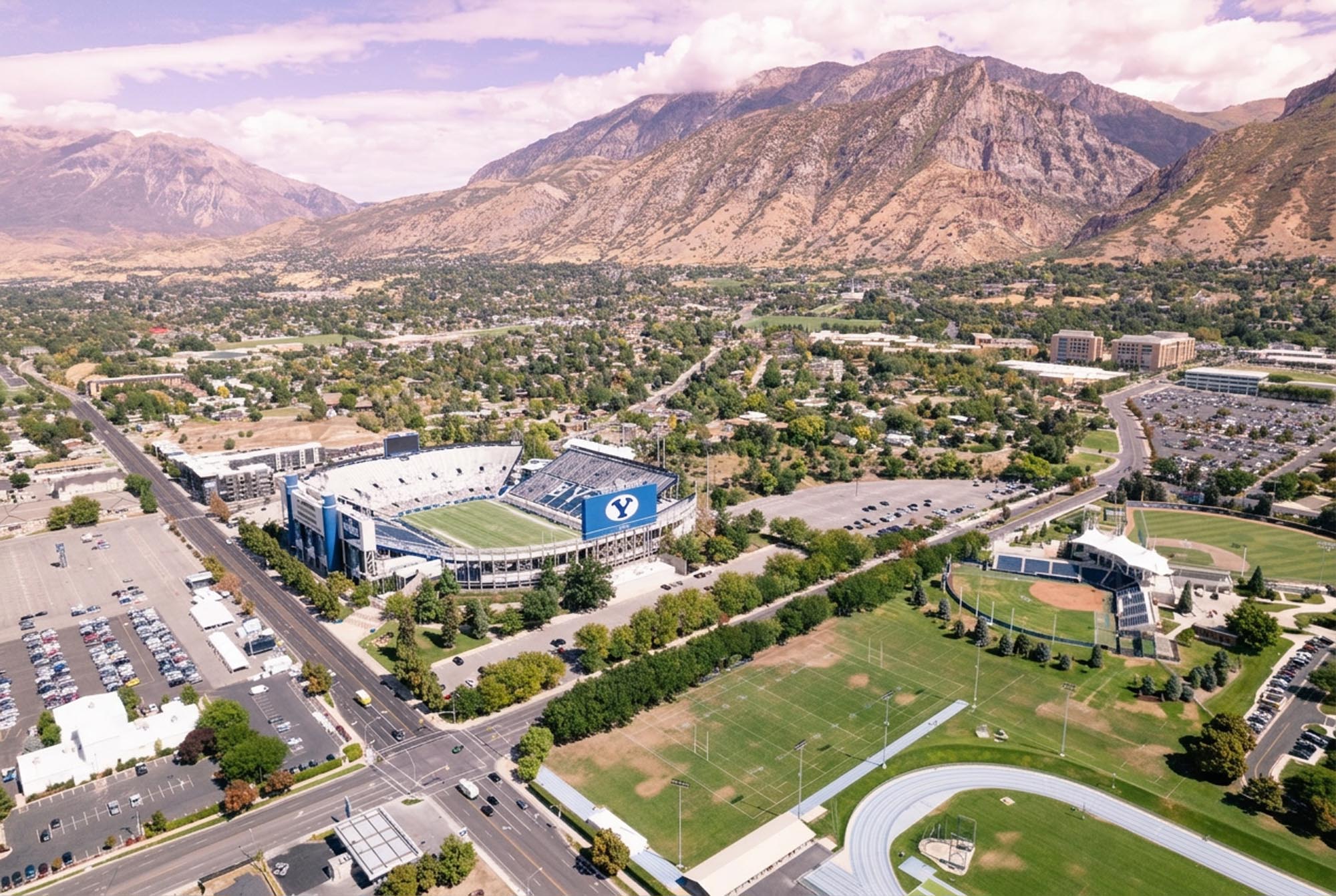 Aerial view of a football stadium surrounded by mountains, showcasing the natural landscape and sports venue in Provo.